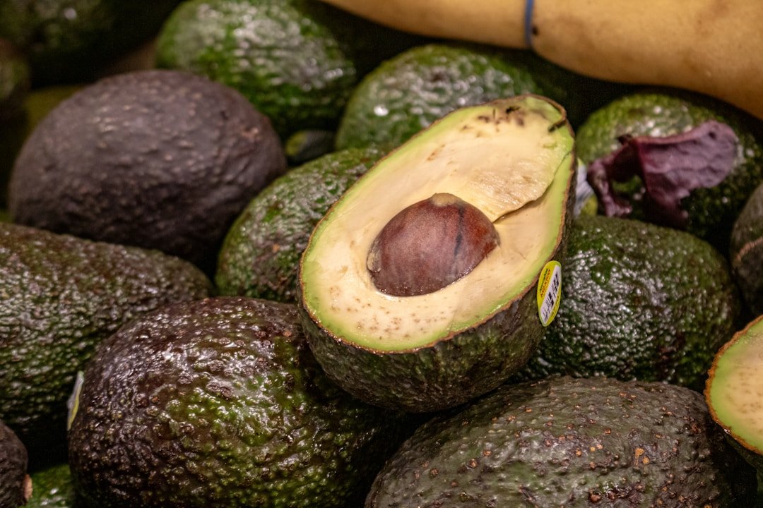 Ripe Kenyan avocados halved to show creamy flesh and pit — Kenyan avocado farming produces premium Hass and Fuerte varieties