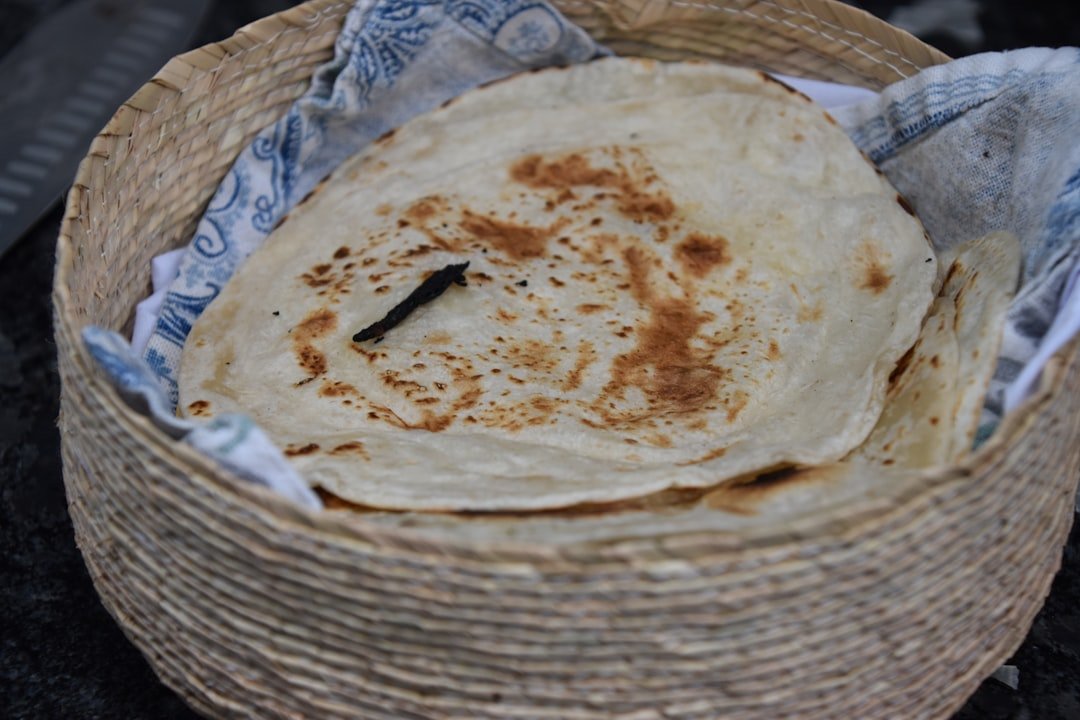 Kenyan chapati dough ingredients including flour, oil and water on a wooden surface